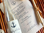 Wedding invitation with bottle and decorative elements on a wooden surface