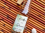Glass bottle with a personalized label on a woven surface