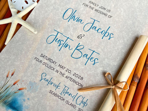 Cattails theme wedding invitation with starfish and rolled paper on a wooden surface