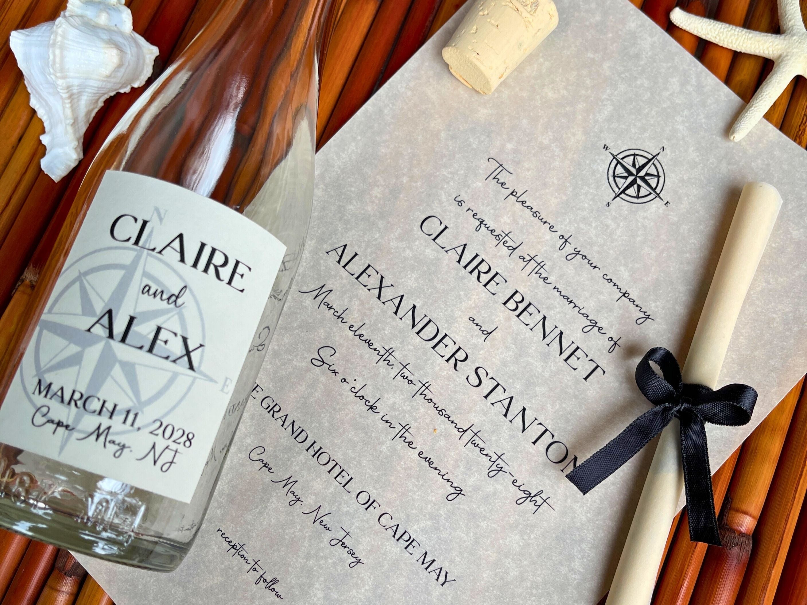 Personalized bottle and invitation with nautical design elements on a wooden surface.