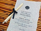 Wedding invitation with a scroll and black ribbon on a textured surface