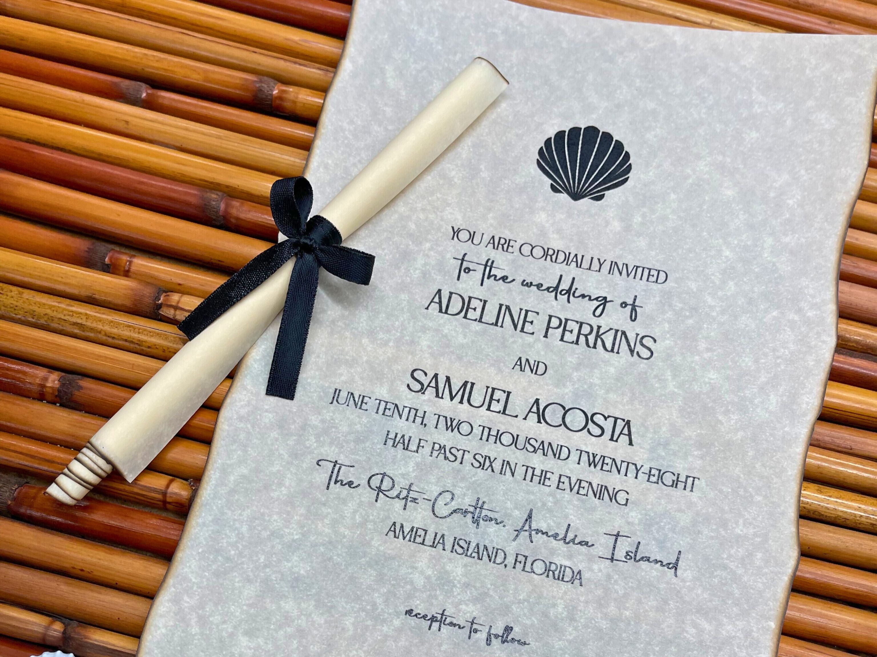 Wedding invitation with a scroll and black ribbon on a textured surface