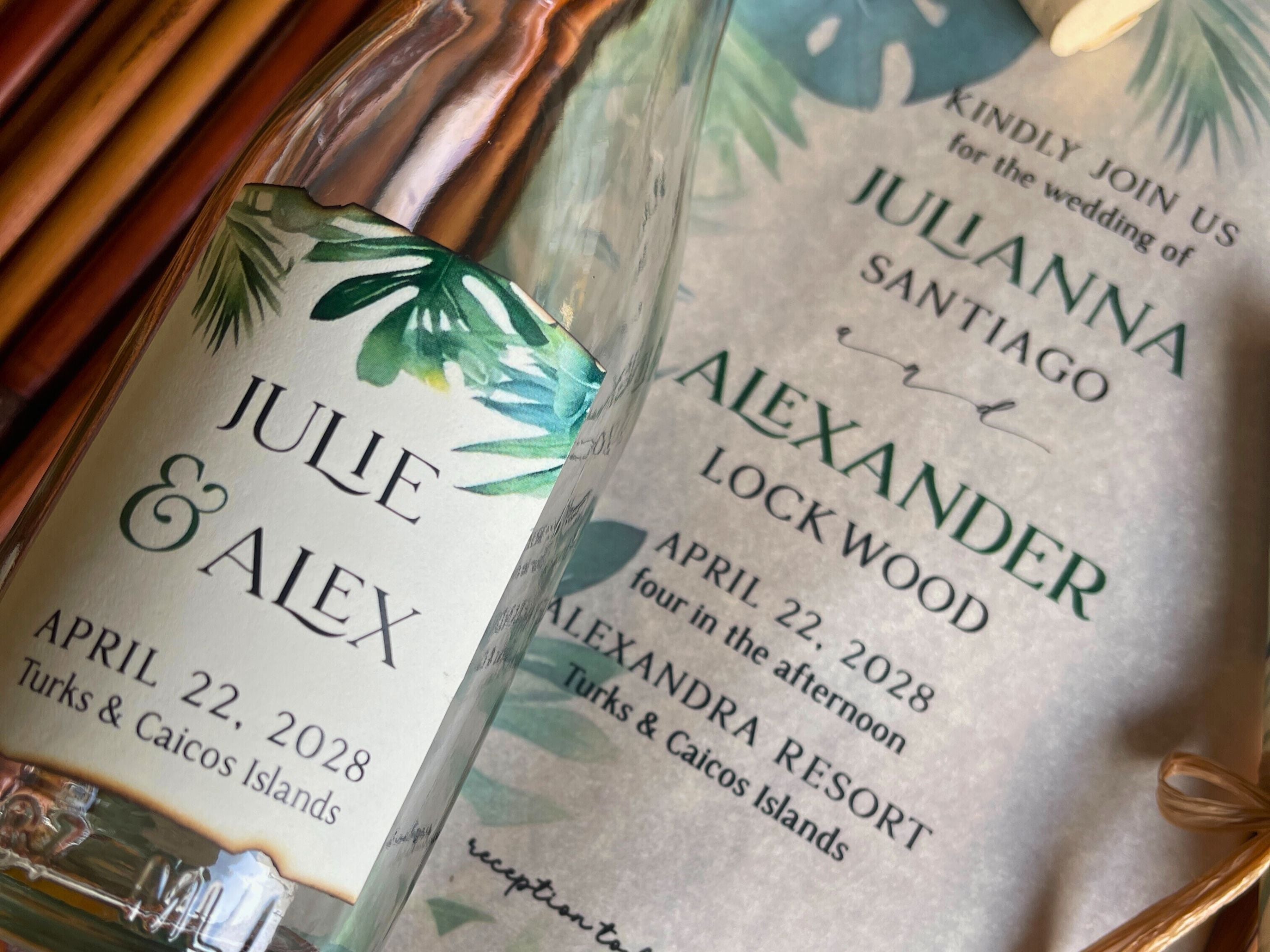Personalized glass bottle with wedding invitation label on a wooden surface.