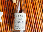 Glass bottle with a personalized label against a bamboo background