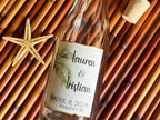 Glass bottle with a personalized label on a woven surface