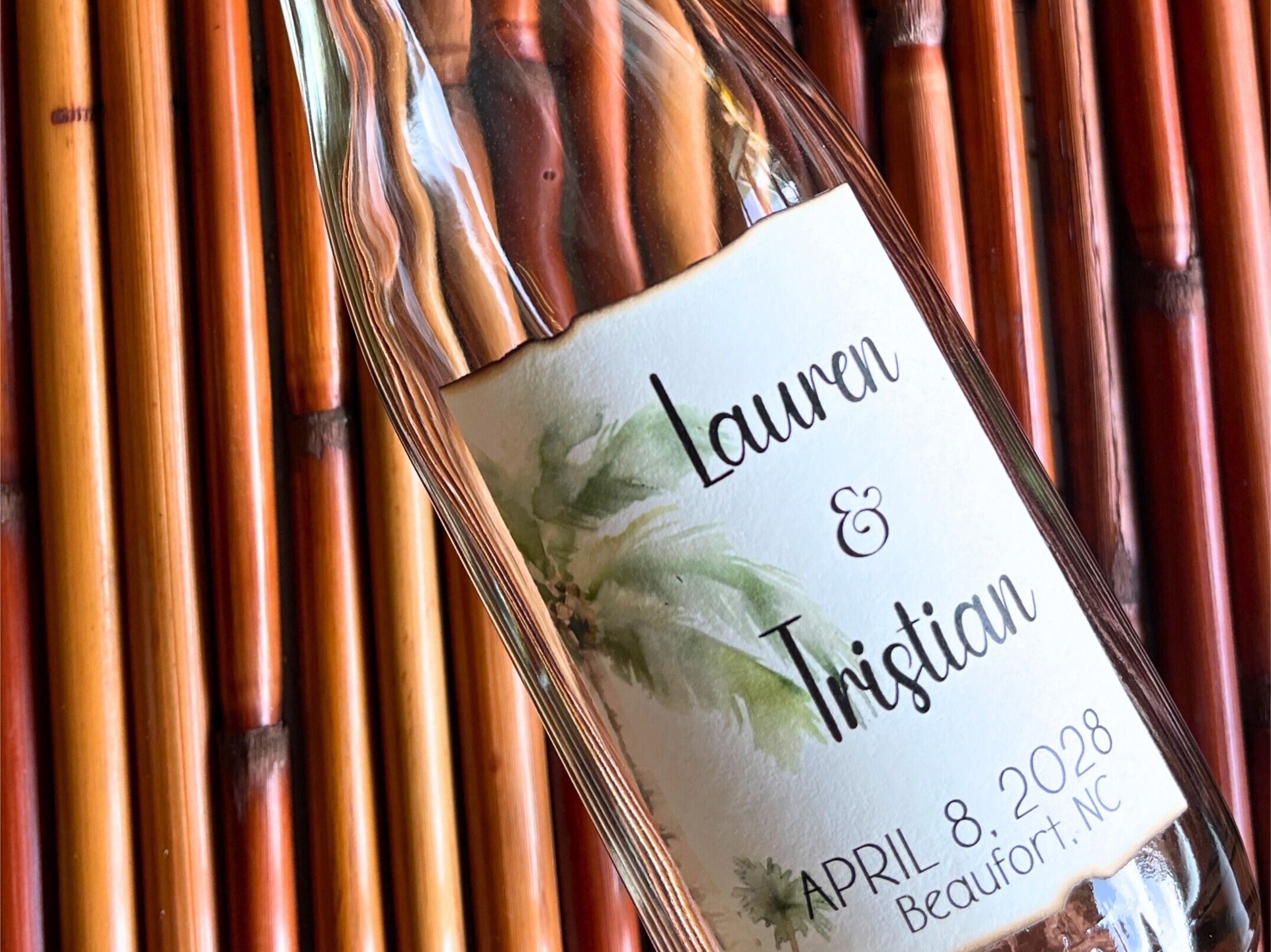 Glass bottle with a personalized label against a bamboo background