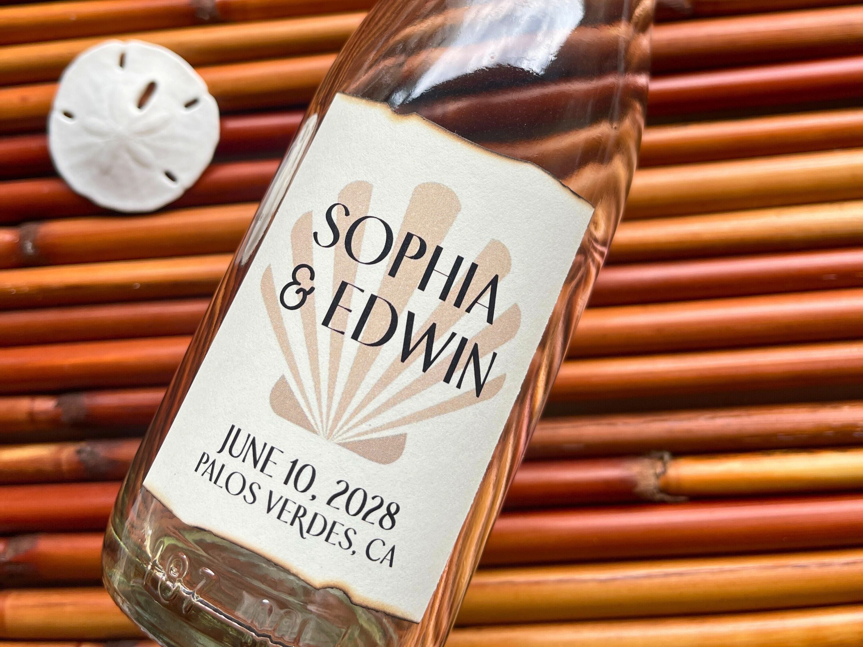 Glass bottle with a personalized label against a woven mat background