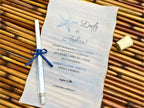 Wedding invitation with a blue ribbon on a woven surface