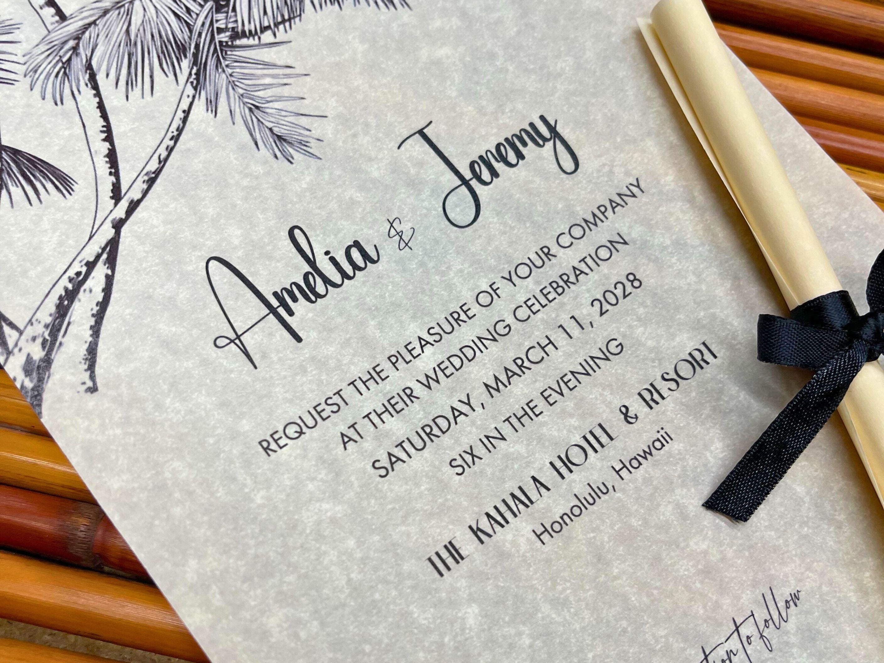 Wedding invitation with black text on a textured surface, featuring a black ribbon and palm tree design.