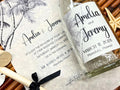 Wedding invitation with palm tree design and a glass bottle.