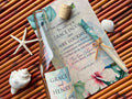 Wedding invitation with bottle and decorative elements on a woven surface