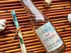 Bottle with an invitation scroll and label on a bamboo surface