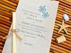 Wedding invitation with turtle design on a textured surface with natural elements.