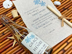 Wedding invitation with bottle and sand dollar on woven mat