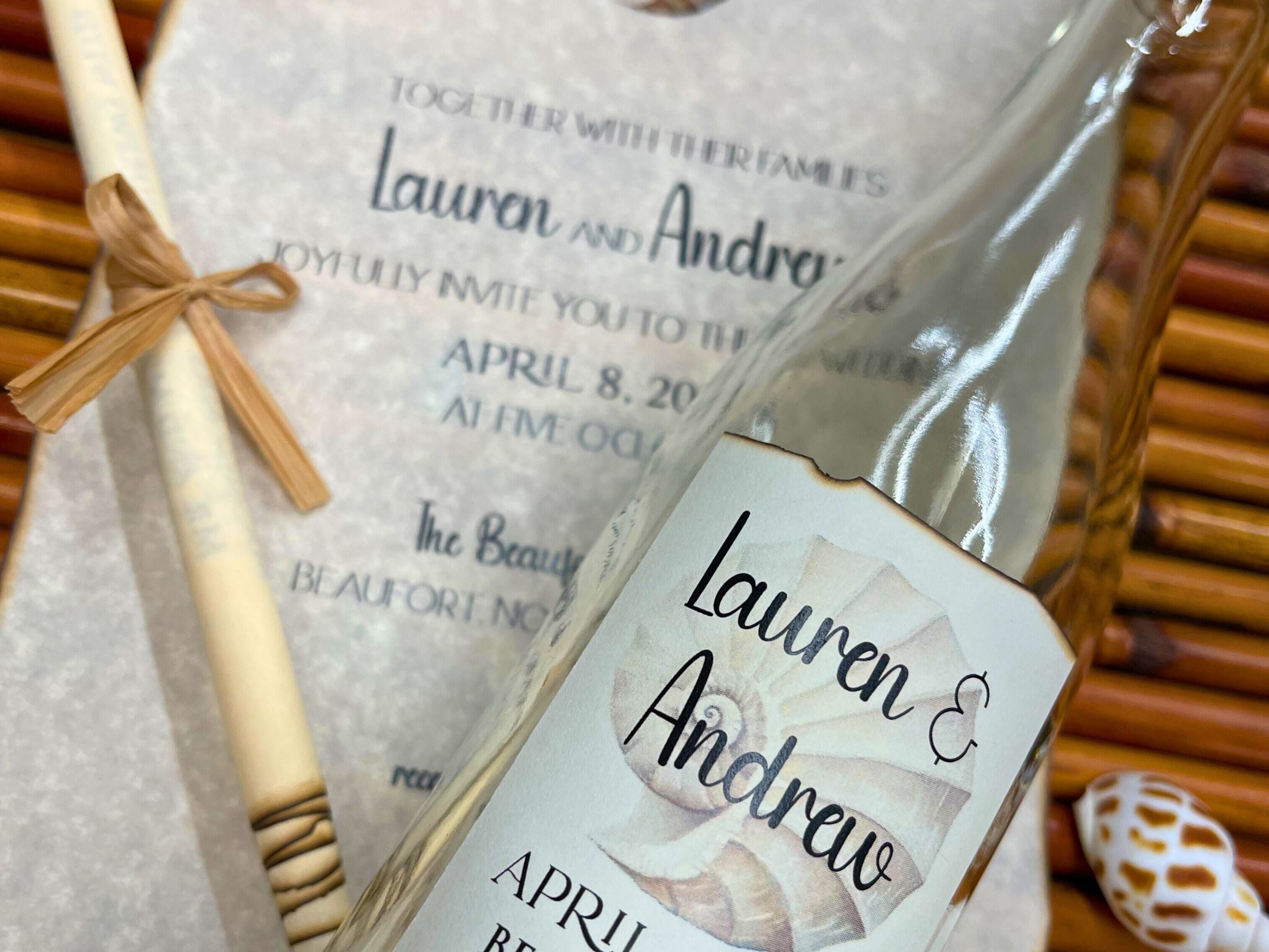 Personalized bottle label and invitation on a woven background.