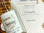 Glass bottle with a wedding invitation label on a textured surface