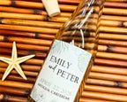 Glass bottle with a personalized label on a woven surface with a starfish.