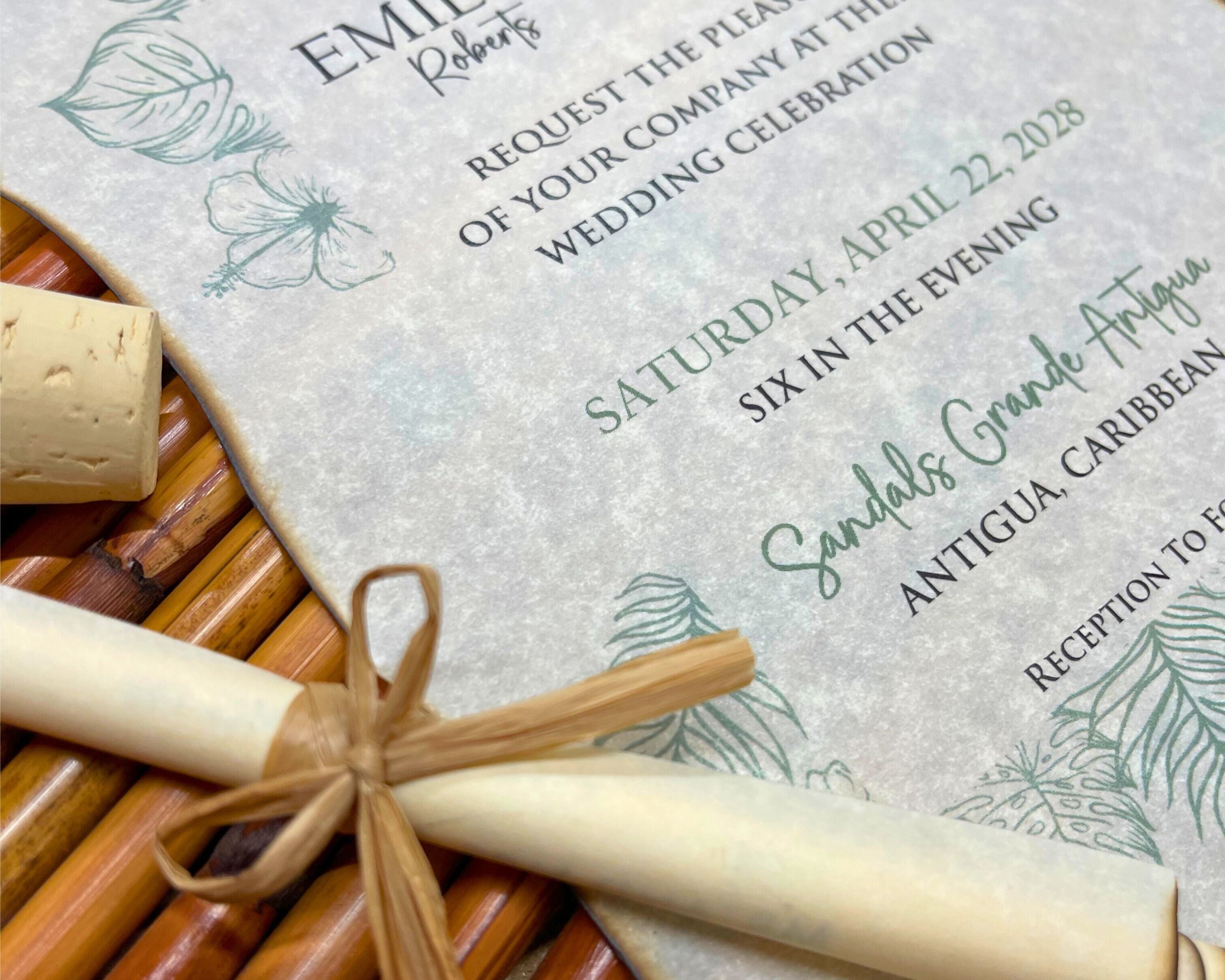 Wedding invitation with green tropical elements on a textured surface