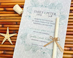 Wedding invitation with scroll on a textured surface with starfish and cork.